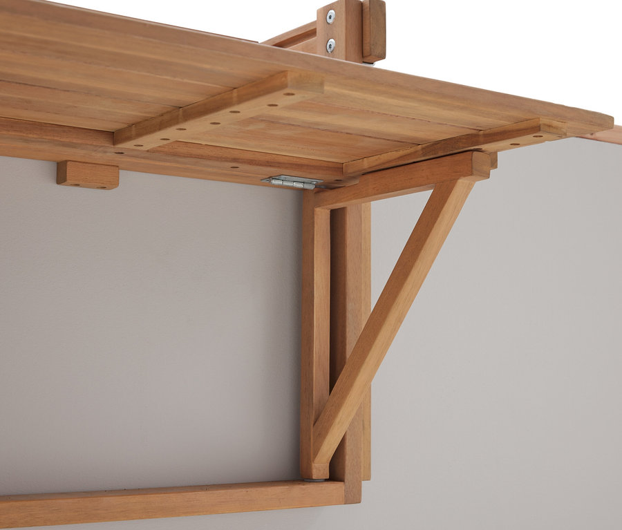 Nahaufnahme eines an einer grauen Wand montierten, heruntergeklappten Holztisches.