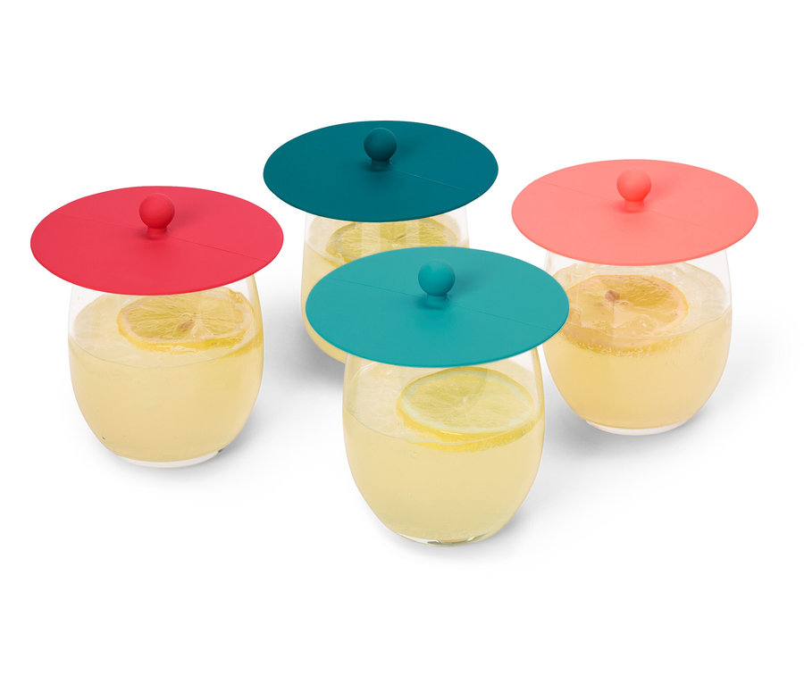 Vier Gläser Limonade mit Zitronenscheiben, abgedeckt mit roten und türkisfarbenen Silikondeckeln, stehen auf einem weißen Hintergrund.