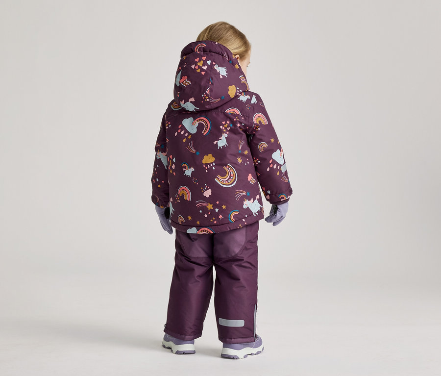 Rückansicht eines Kindes mit blonden Haaren in einer lila Jacke mit Kapuze und Regenbogenmuster, lila Hose, Handschuhen und Schuhen.