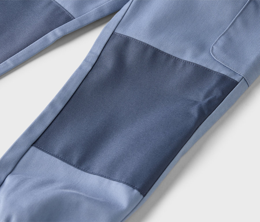 Nahaufnahme einer blauen Hose mit dunkleren blauen Flicken.