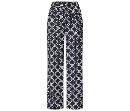Eine Hose mit einem geometrischen Muster in Schwarz und Weiß liegt auf einem weißen Hintergrund.