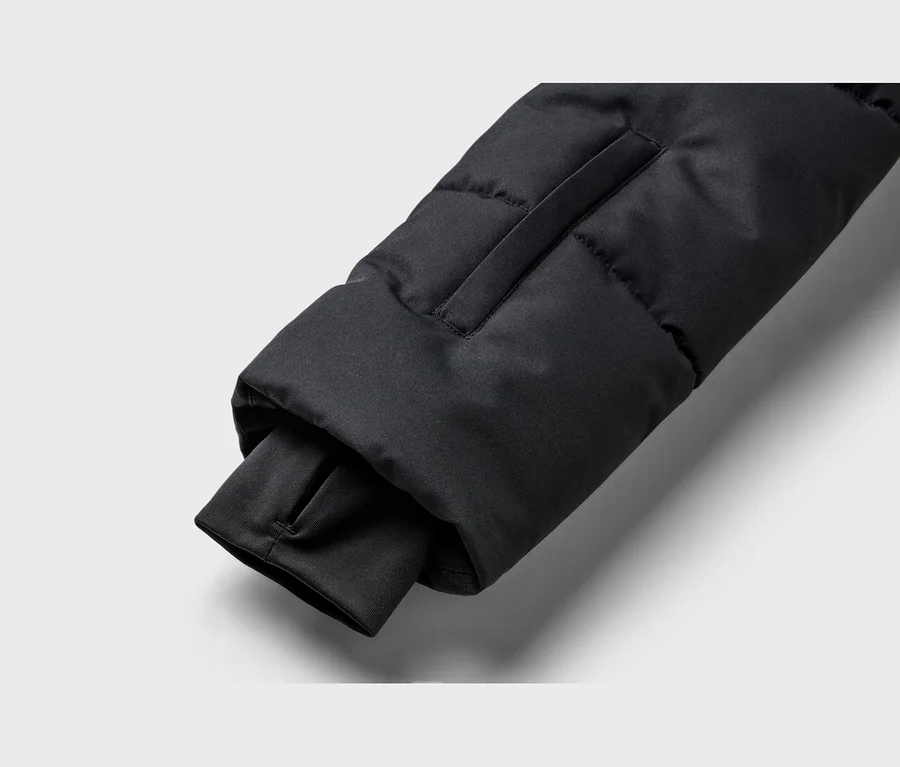 Schwarzer Ärmel einer Steppjacke mit geripptem Bündchen und Daumenloch.