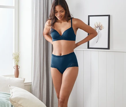 Frau posiert in dunkelblauer Highwaist-Panty und BH.