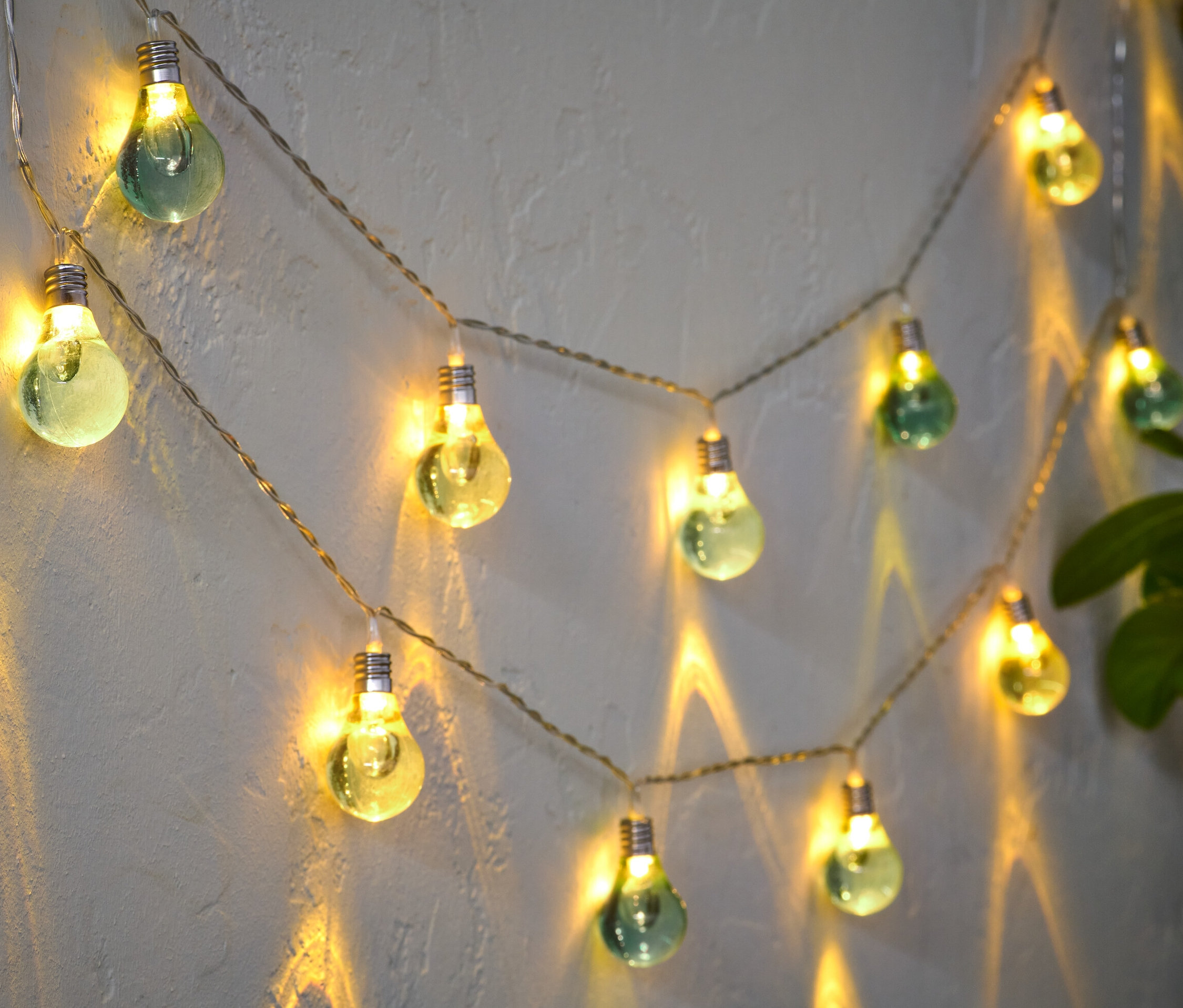 LED-Lichterkette »Glühbirnen« hängt an der Wand und leuchtet.