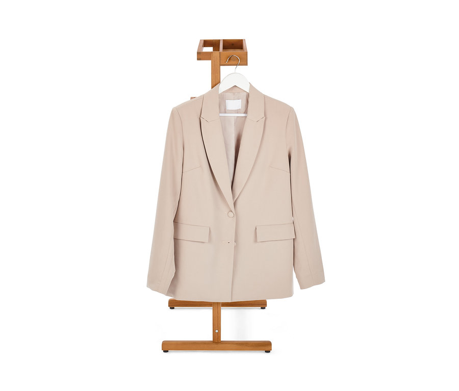 Beiger Blazer hängt an einem Stummer Diener.