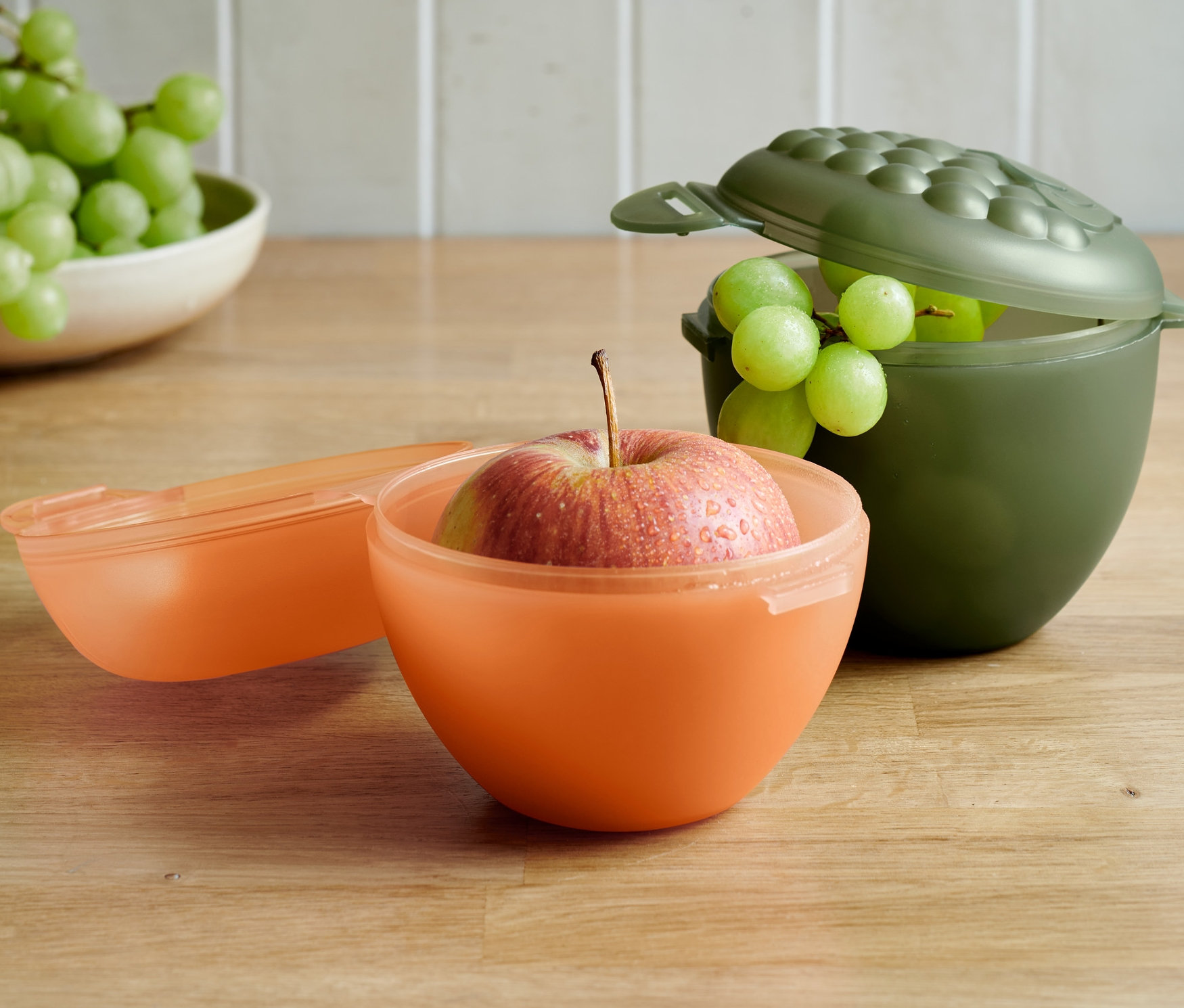 Apfel in orangefarbener und Trauben in olivgrünem Apfel- und Traubenbox-Set.
