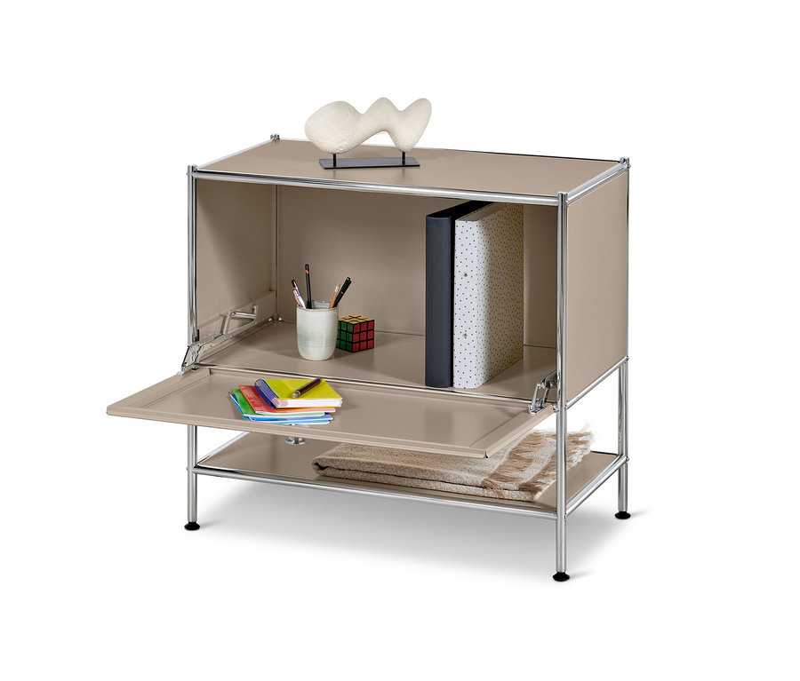 Taupefarbenes Sideboard Metall »CN3« mit Klappe, auf der Notizblöcke und Stifte liegen.