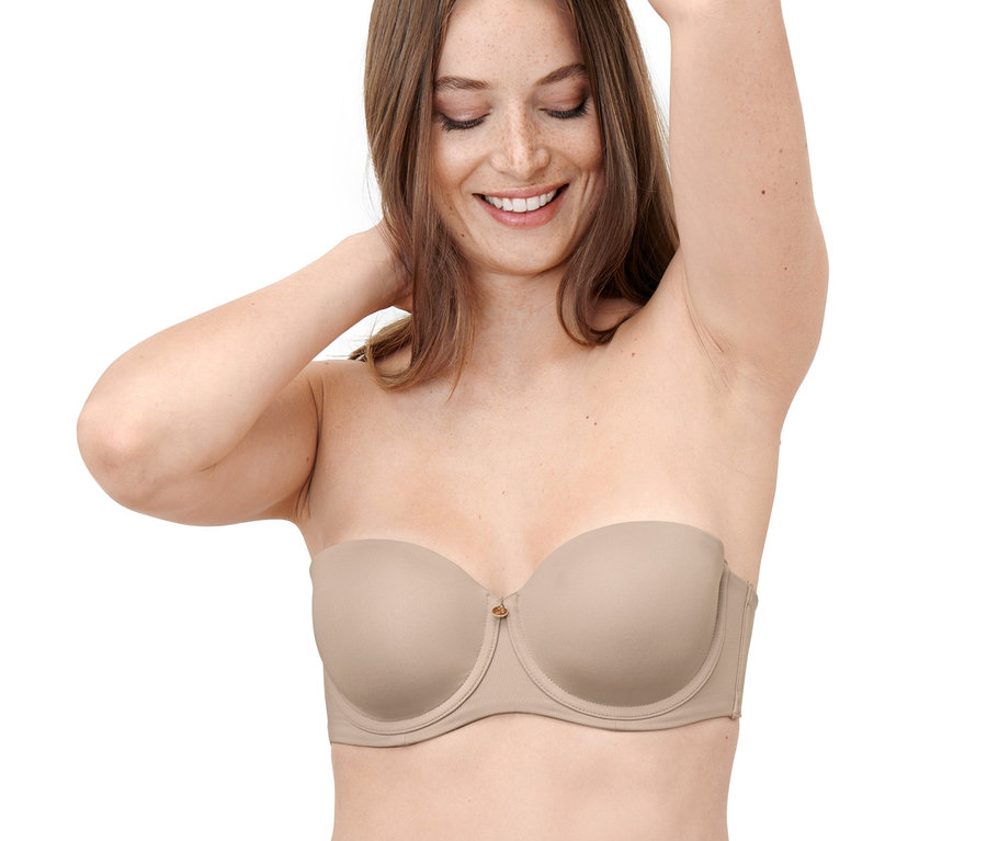 Frau lächelt und posiert in einem Multistyle-BH.