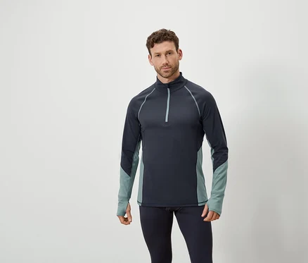 Mann posiert in marineblauem Langarmshirt mit Reißverschluss und marineblauen Leggings.
