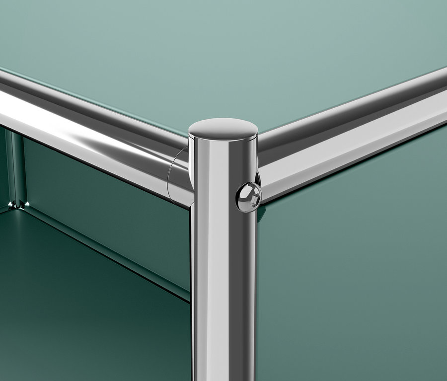 Detail einer grünen Möbel-Ecke mit einem verchromten Bein.