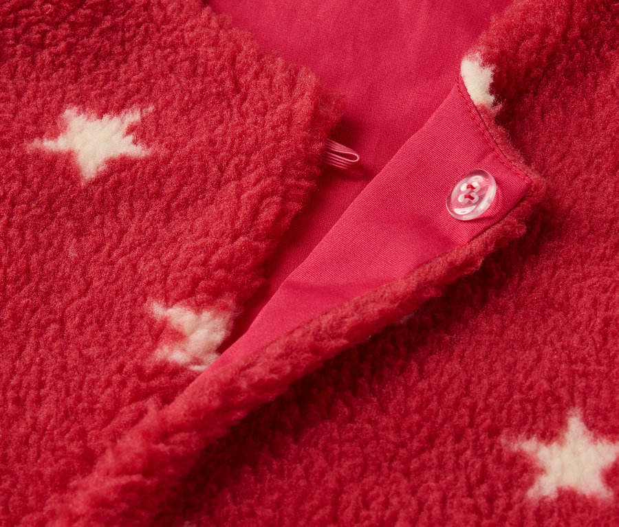 Detail einer roten Kinder-Teddyweste mit weißen Sternen und Knopfverschluss.