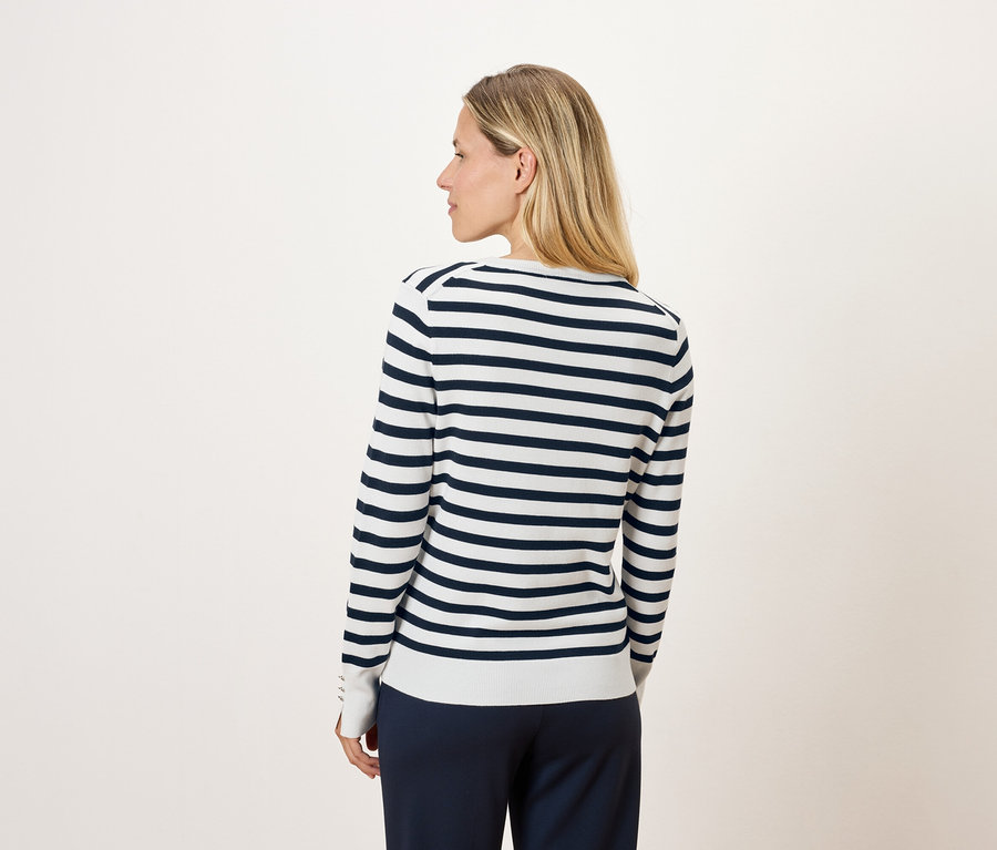 Blonde Frau von hinten in einem gestreiften Langarmpullover.