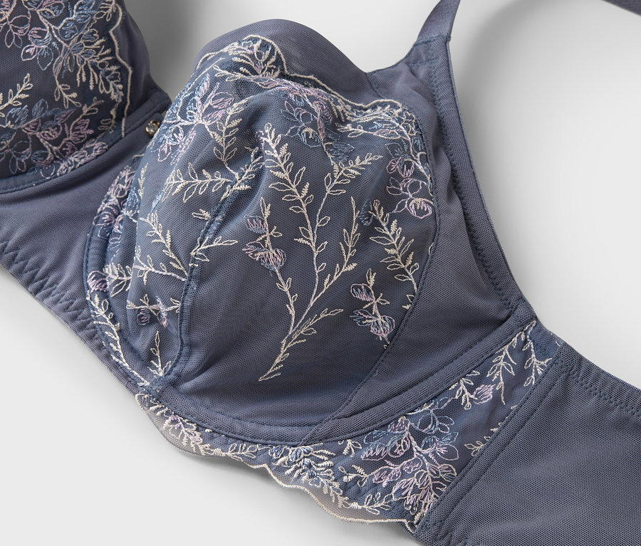 Detailaufnahme eines blauen BHs mit floraler Stickerei.