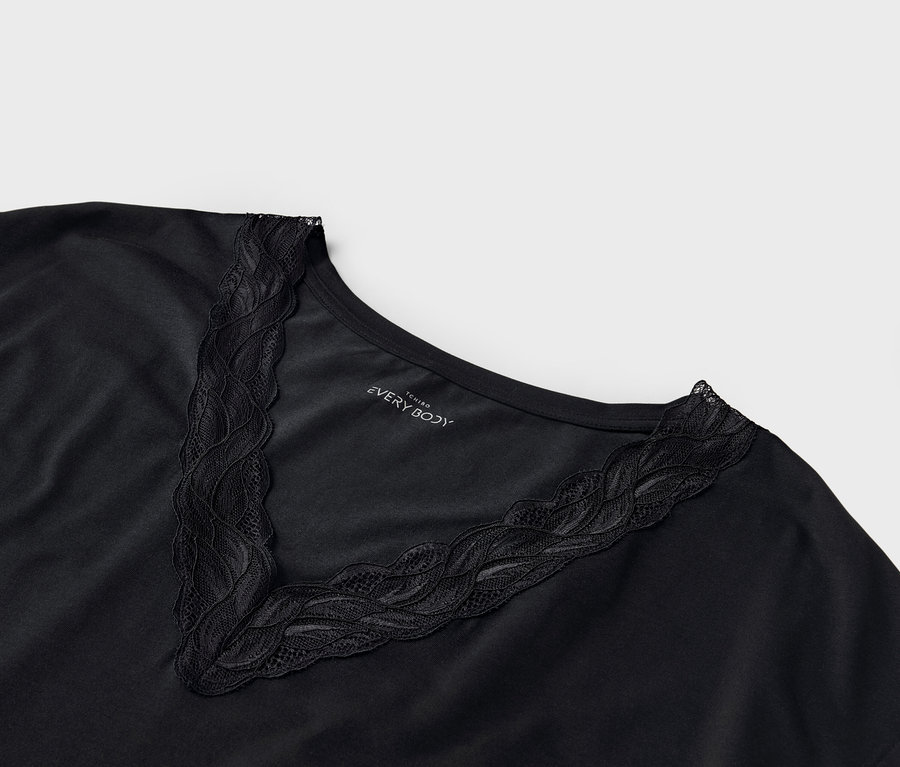 Nahaufnahme eines schwarzen T-Shirts mit Spitzenbesatz am V-Ausschnitt.