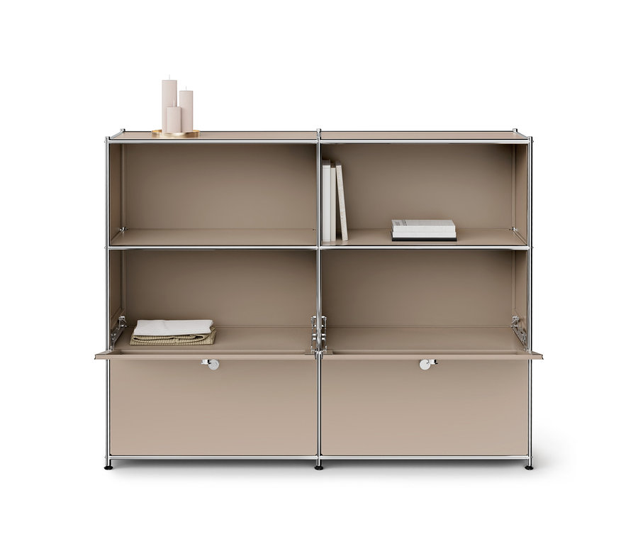 Beiges modulares Regal mit sechs Fächern und Chromrahmen. Auf dem oberen linken Fach stehen drei beigefarbene Kerzen auf einem goldenen Tablett. Das obere rechte Fach enthält vier weiße Bücher. Die untere linke Schranktür ist geöffnet und zeigt gefaltete beigefarbene Handtücher. Die untere rechte Schranktür ist ebenfalls geöffnet und zeigt einen leeren Raum.