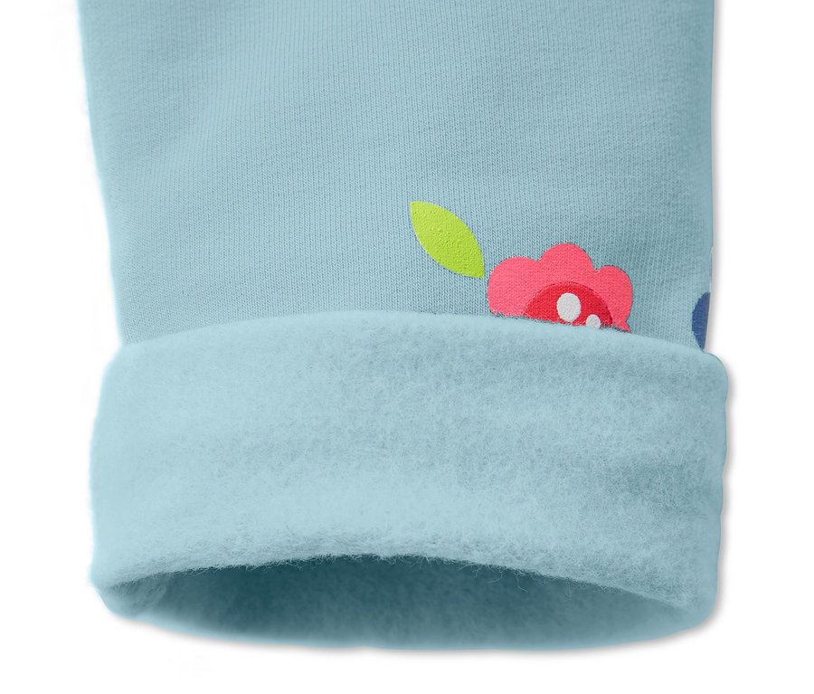 Detail einer hellblauen Sweathose mit Blumenmuster und umgeschlagenem Saum.