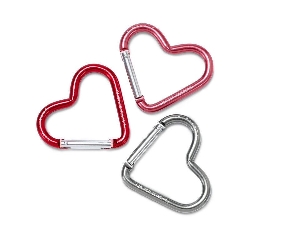 Drei herzförmige Karabinerhaken in Rot, Pink und Silber.