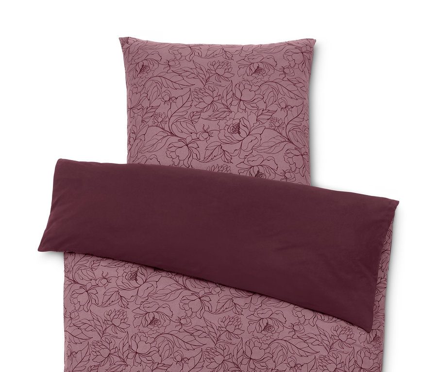 Eine Winterjersey-Bettwäsche mit Blumenmuster und einem bordeauxroten Kissenbezug.