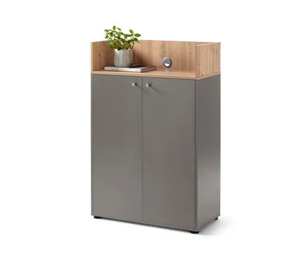 Graues Highboard mit 2 Türen und einer Holzplatte, auf der sich eine Topfpflanze und ein Buch befinden.