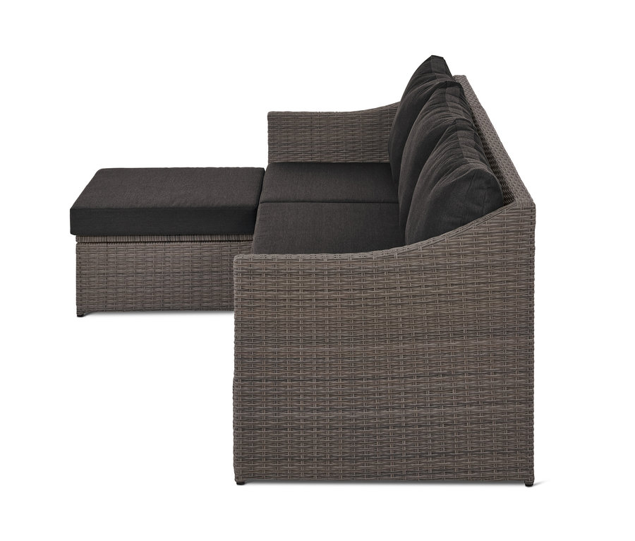Graues Auszieh-Schlafsofa »Thore« mit Stauraum und dunkelgrauen Kissen aus Polyrattan.