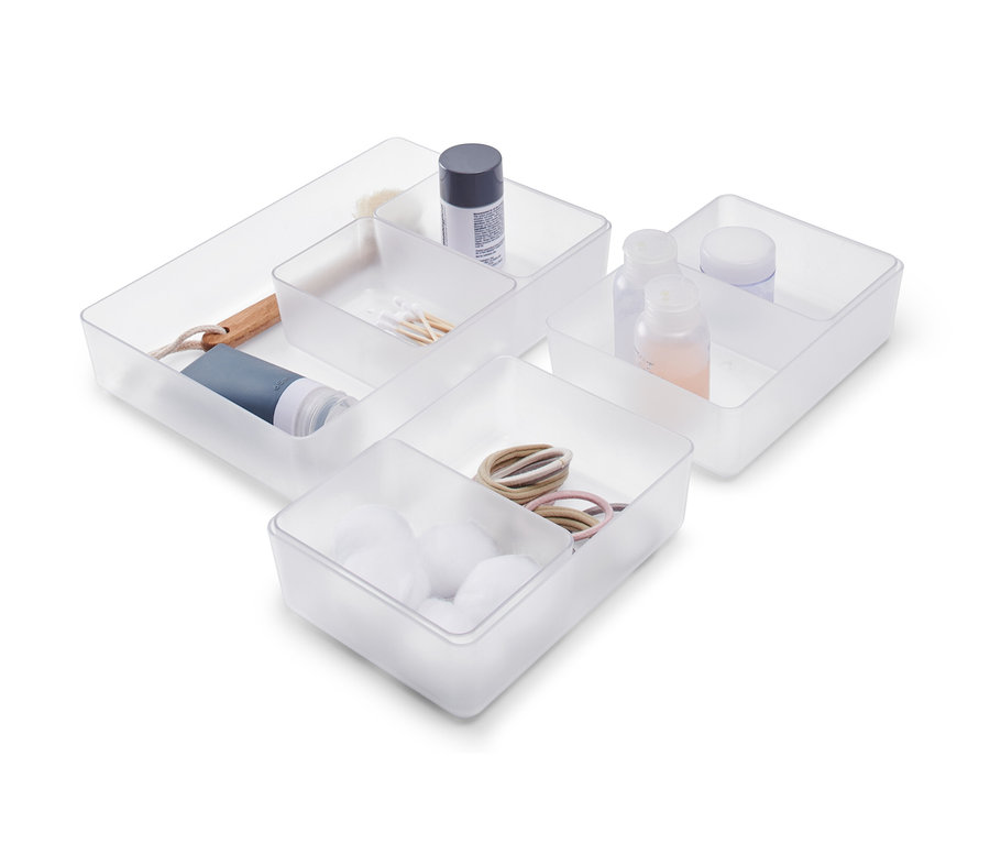 Ein Schubladen-Organizer-Set mit Wattebäuschen, Haargummis, Wattestäbchen, Flaschen und einer Bürste.