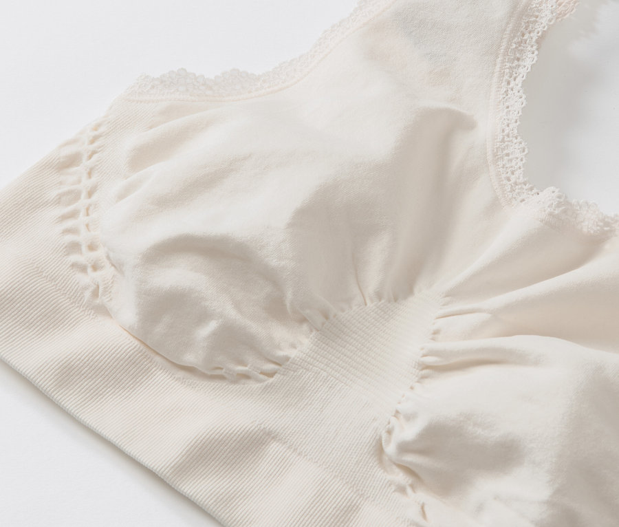 Detailansicht eines creme Seamless-Bustiers mit Spitze.