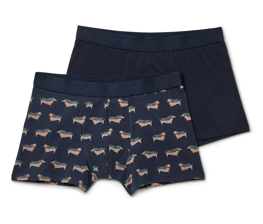 Zwei Herren-Boxershorts: eine mit Dackel-Weihnachtsmotiv, die andere marineblau.