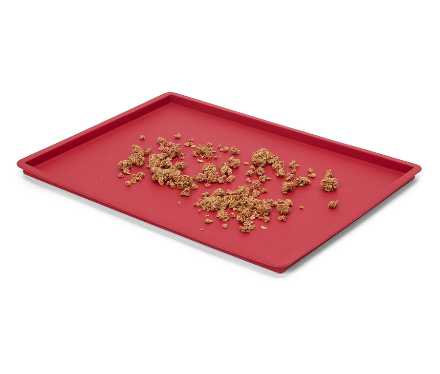 Rotes Tablett mit zerbröseltem Müsli.