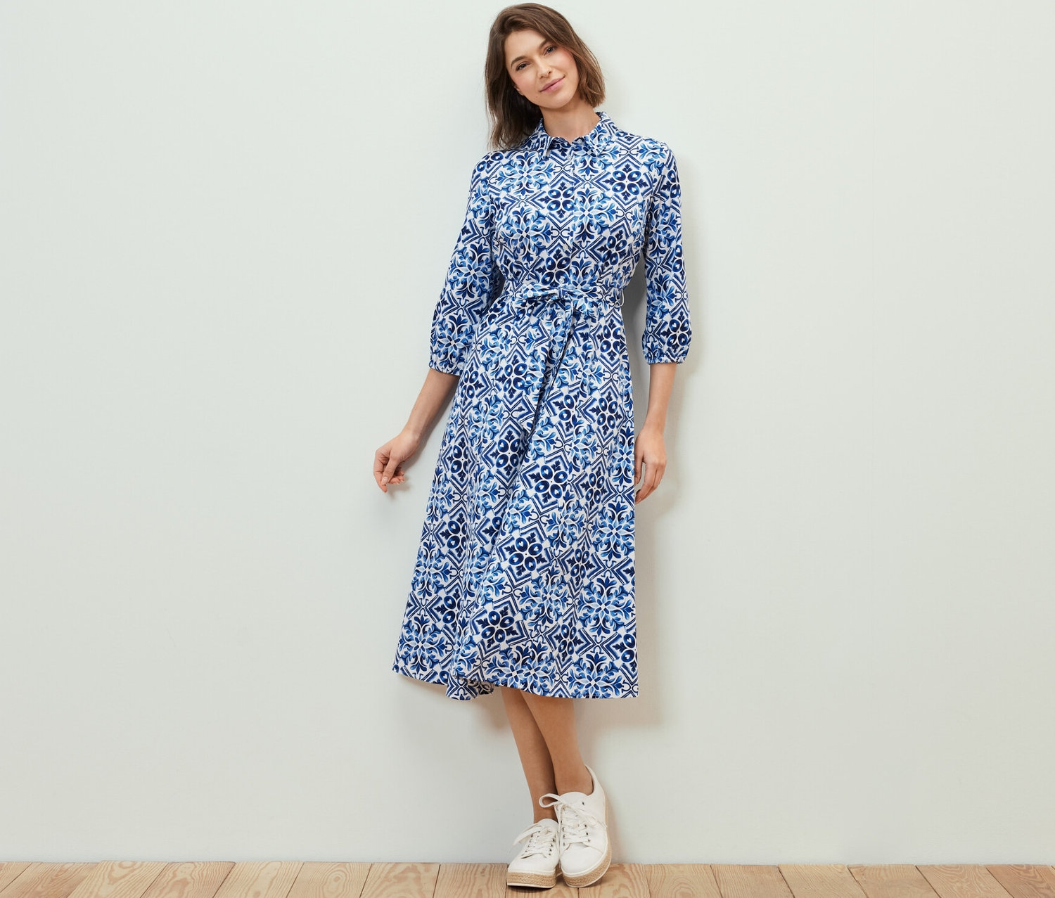 Frau posiert in einem bedruckten Midikleid.