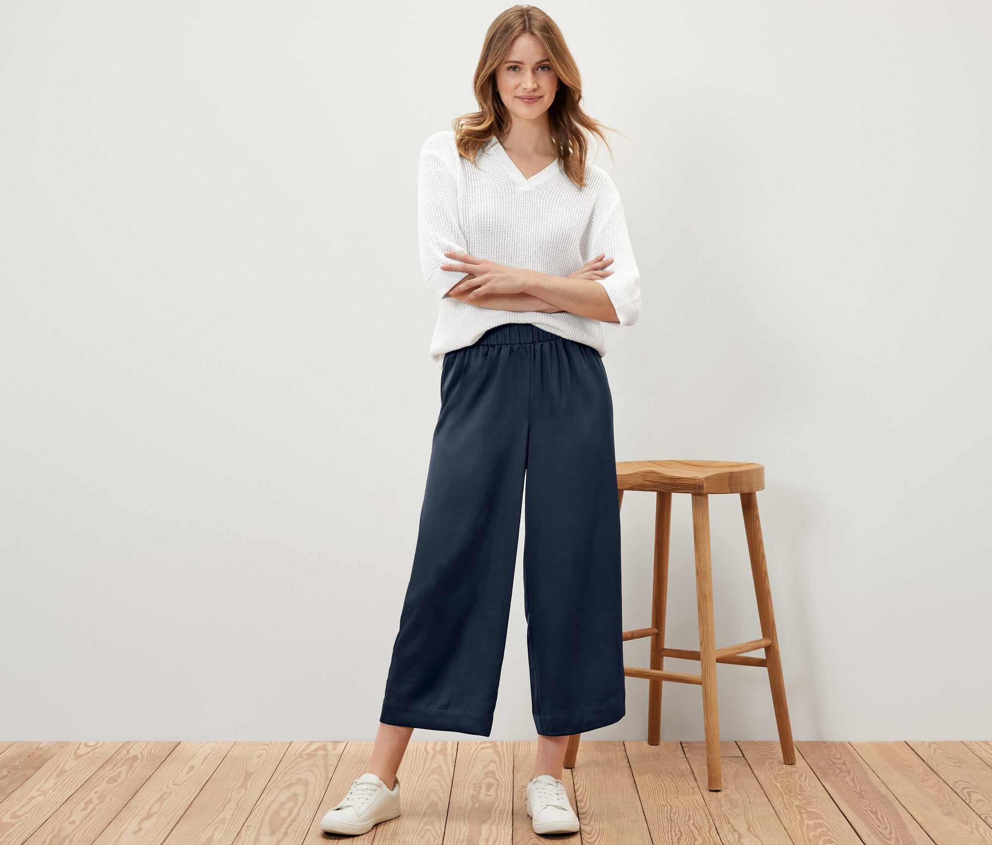 Frau posiert in marineblauer Satinhose.