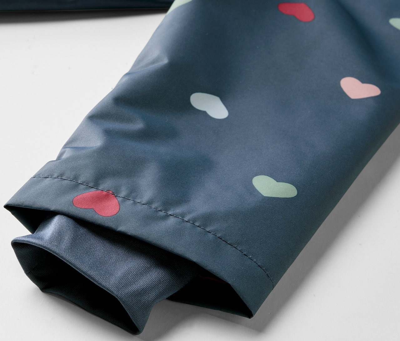 Detailansicht einer Kinder-Thermo-Regenjacke mit Herzchenmuster.