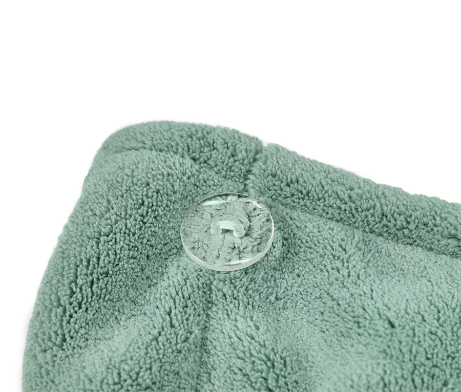 Nahaufnahme eines türkisgrünen Handtuch-Turbans mit transparentem Knopf.