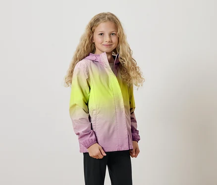 Mädchen mit langen blonden Locken trägt eine Kapuzenjacke mit Farbverlauf von Gelb nach Lila.