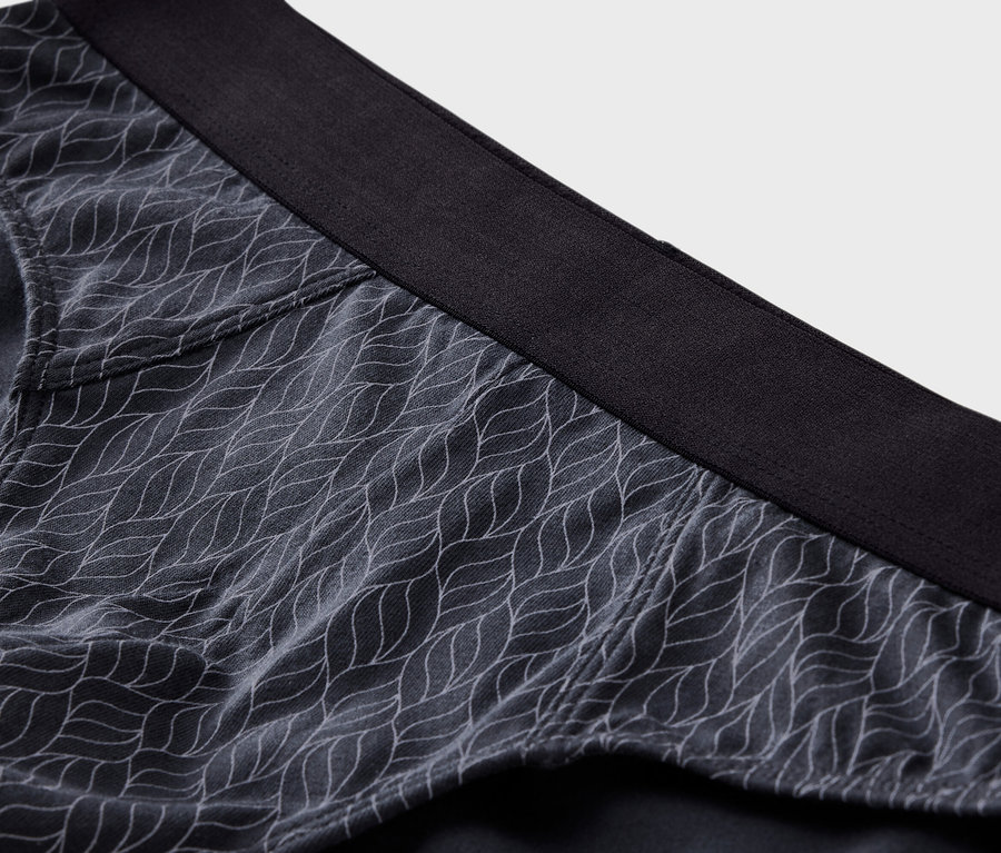 Nahaufnahme einer grauen Unterhose mit weißem Muster und schwarzem Bund.