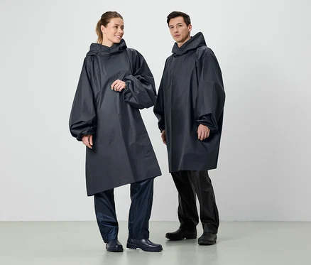 Zwei Personen stehen nebeneinander und tragen dunkelblaue Regenponchos mit Kapuze.