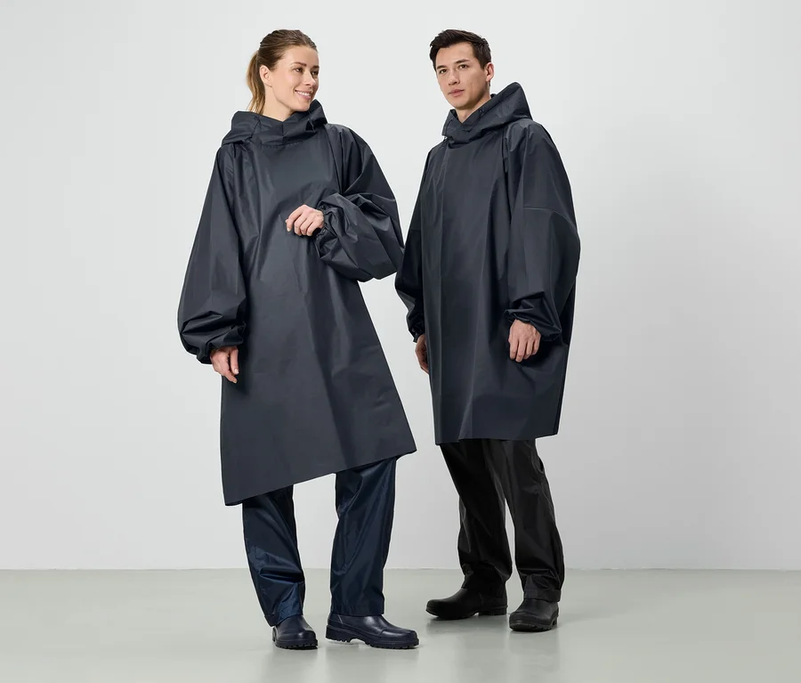 Zwei Personen stehen nebeneinander und tragen dunkelblaue Regenponchos mit Kapuze.