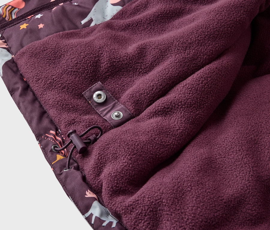 Nahaufnahme einer burgunderfarbenen Jacke mit Einhorn-Muster und Fleece-Futter, das mit Druckknöpfen und Kordelzug befestigt ist.