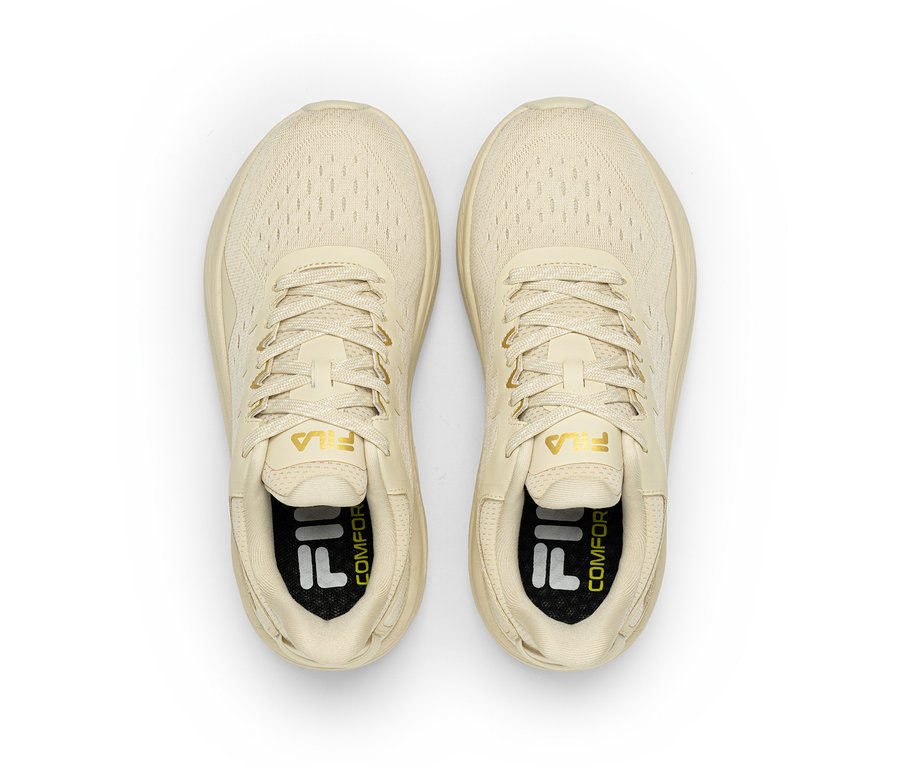 Ein Paar cremefarbener Fila-Sneaker mit Schnürsenkeln, von oben gesehen. Das Fila-Logo ist auf der Zunge und der Innensohle sichtbar.