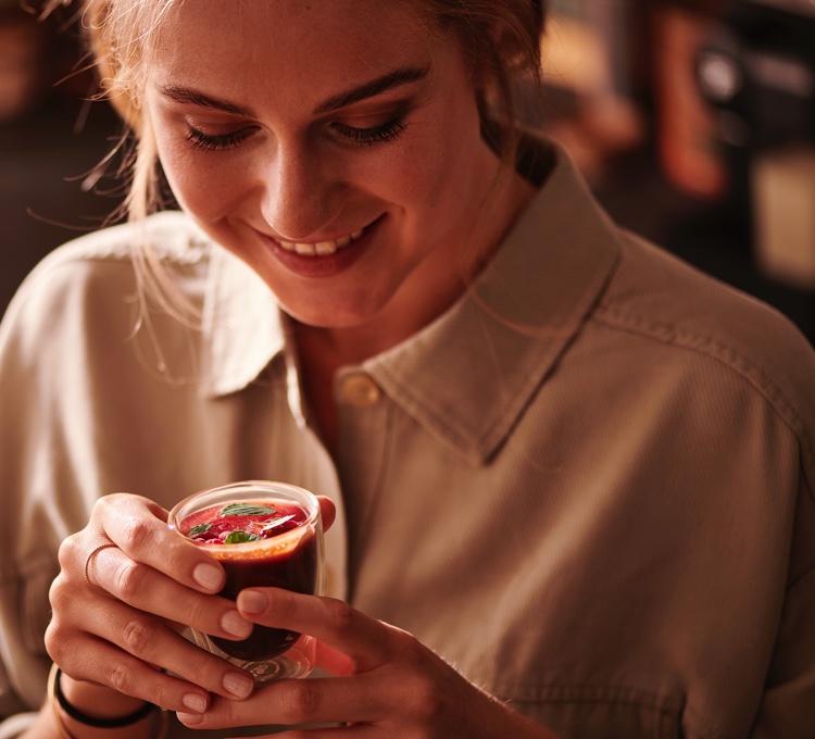 Eine Frau hält einen Iced Raspberry Espresso in der Hand