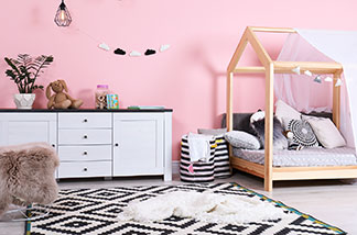 Einsatz auch im Kinderzimmer: Ein weisses Sideboard in einem Mädchen-Kinderzimmer mit rosafarbener Wand.
