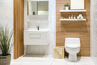 Ein Badezimmer mit einem rechteckigen Waschtisch, neben dem eine Toilette mit ovalem, weissem Toilettendeckel steht.