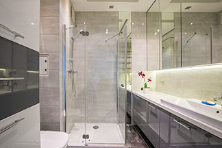 Tipps für kleine Bäder: Ein Badezimmer mit einer grosser Spiegelfläche und einer verglasten Dusche.