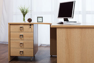 Platzsparende Alternative zum Büroschrank: Schreibtisch mit Schubladenunterschrank, ein Fach ist abschliessbar.