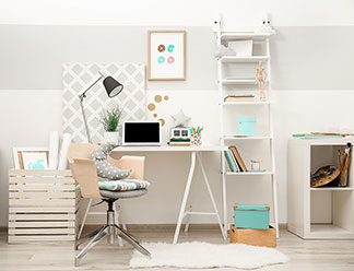 Büroausstattung in guter Qualität: Ein Arbeitszimmer mit weissem Schreibtisch, einem weissen, hohen, offenen Regal und einem Bürostuhl.