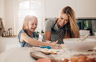 Eine Mutter backt mit ihrer Tochter Plätzchen.